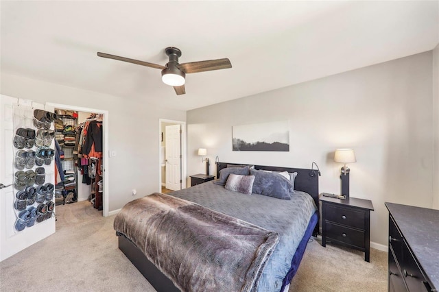 carpeted bedroom featuring ceiling fan, a spacious closet, and a closet