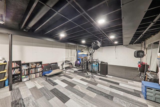 basement featuring carpet and brick wall