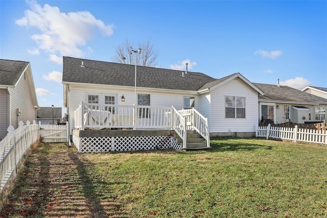 back of property featuring a wooden deck and a yard