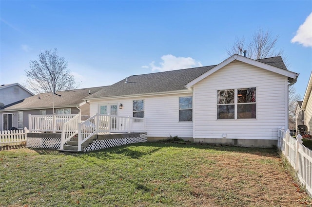 rear view of property featuring a yard and a wooden deck