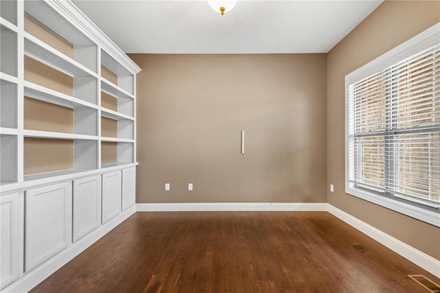 empty room with dark hardwood / wood-style flooring