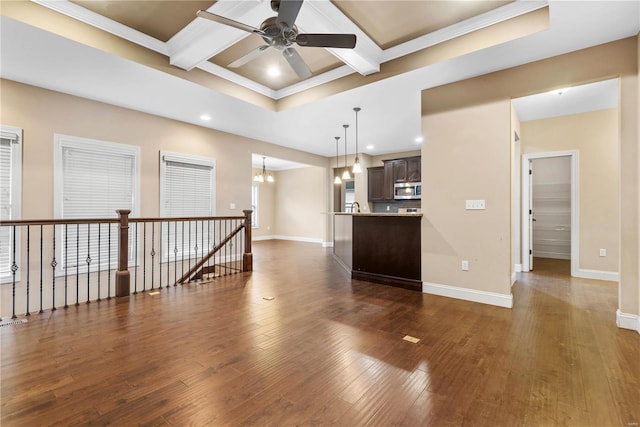 living room featuring ornamental molding, coffered ceiling, ceiling fan with notable chandelier, beamed ceiling, and dark hardwood / wood-style floors