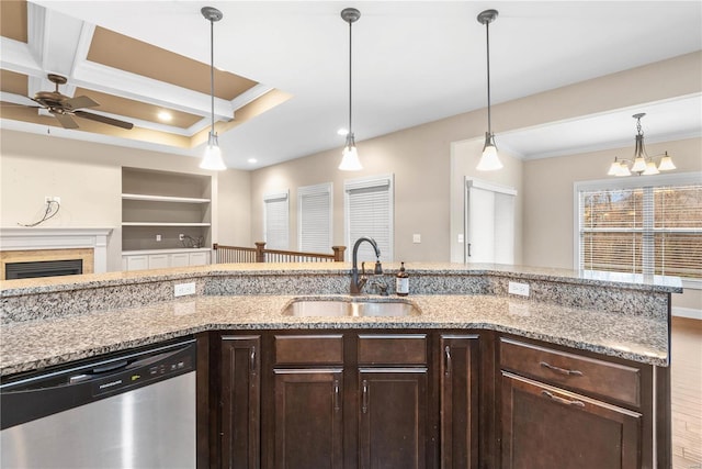 kitchen featuring dishwasher, sink, built in features, pendant lighting, and ceiling fan with notable chandelier