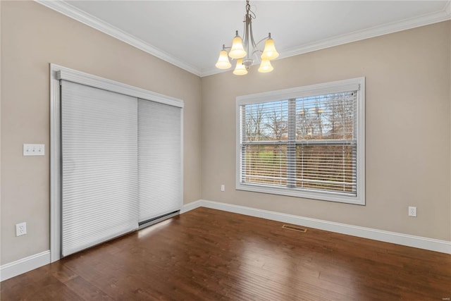 unfurnished bedroom featuring crown molding, a closet, dark wood-type flooring, and a notable chandelier