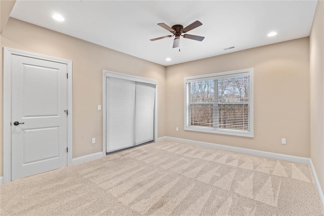 unfurnished bedroom with ceiling fan and light colored carpet