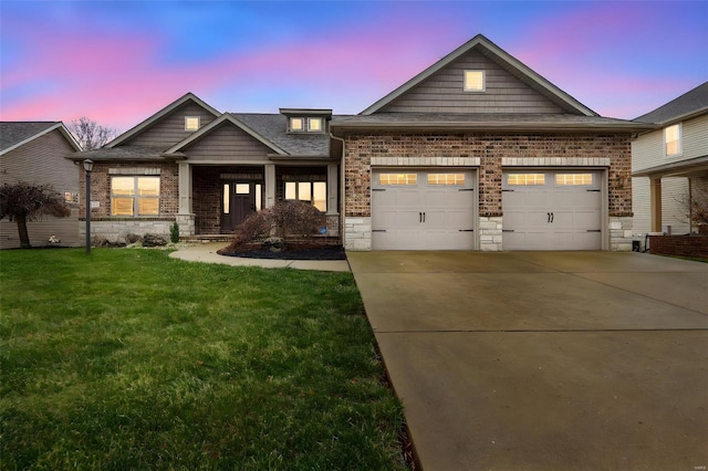 craftsman inspired home featuring a garage and a lawn