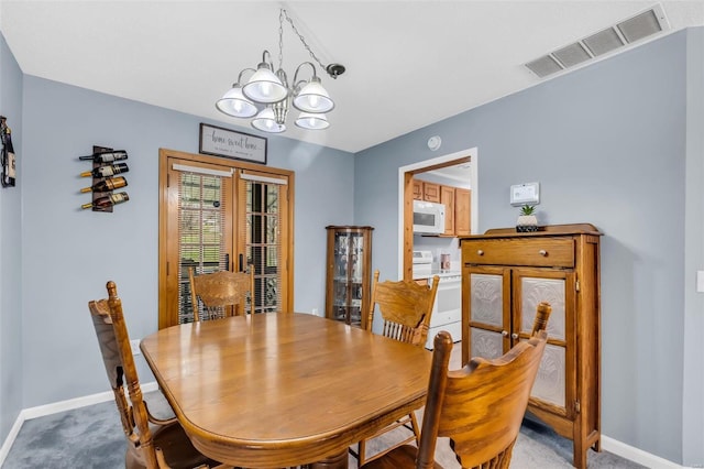 dining room featuring carpet floors and a notable chandelier