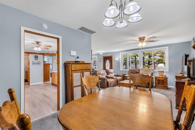 dining area featuring ceiling fan with notable chandelier and light colored carpet