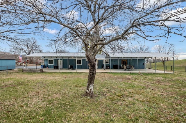 rear view of house with a patio and a lawn