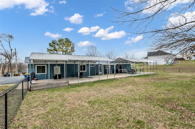 rear view of house featuring a lawn and a patio