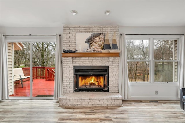 interior space with hardwood / wood-style flooring and a brick fireplace