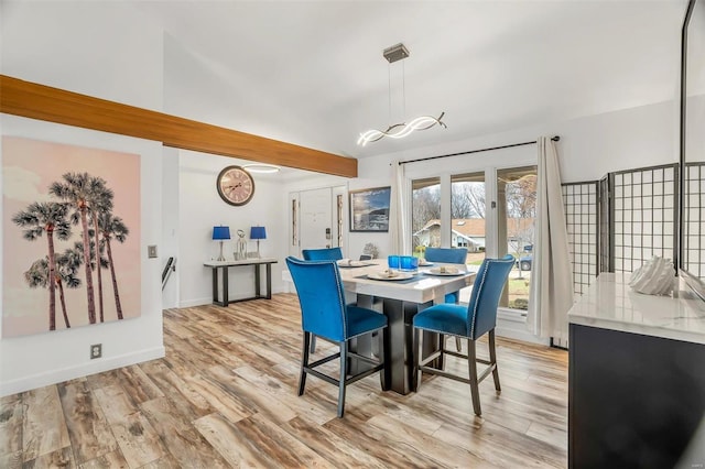 dining space featuring lofted ceiling and light hardwood / wood-style flooring