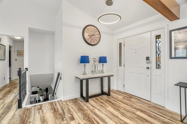 entryway featuring vaulted ceiling with beams and light wood-type flooring