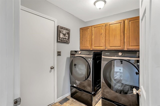 laundry area featuring cabinets, independent washer and dryer, and light tile patterned floors