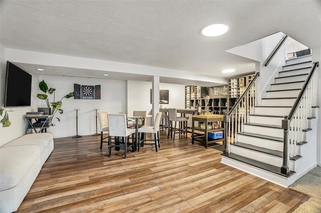 dining space with hardwood / wood-style floors and a textured ceiling