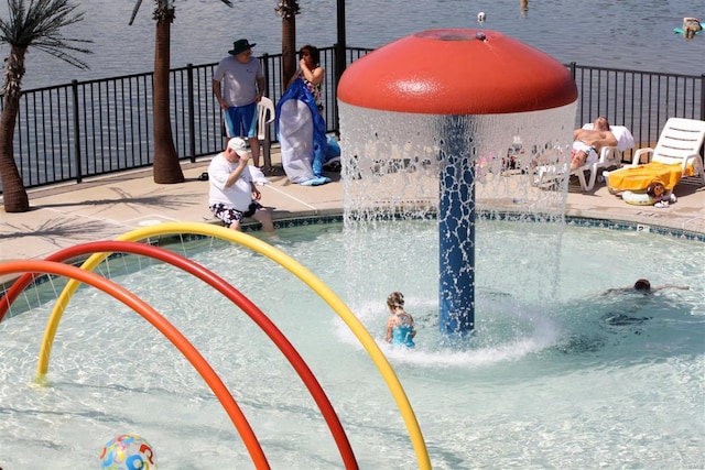 view of swimming pool featuring pool water feature and a water view