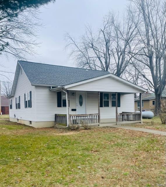 ranch-style house featuring a porch and a front lawn