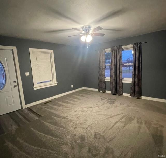 foyer entrance with carpet flooring and ceiling fan