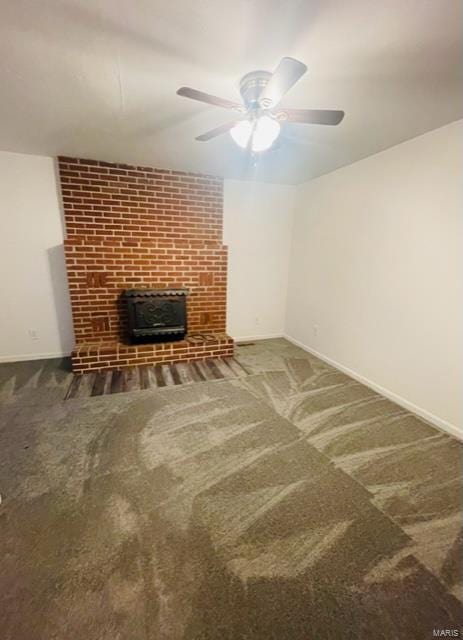 unfurnished living room with ceiling fan, a fireplace, and carpet