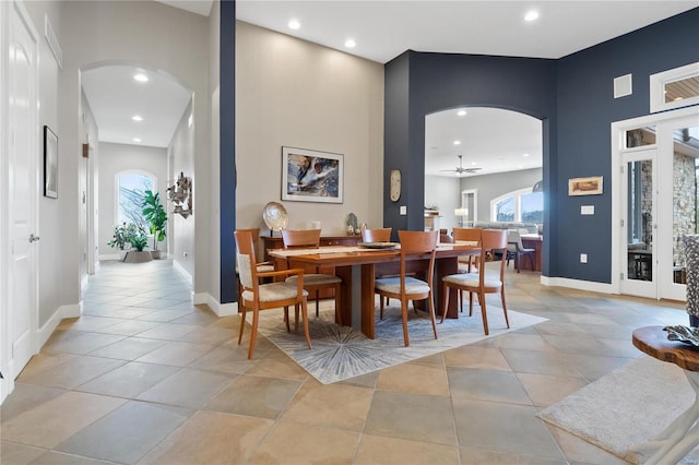 dining area featuring ceiling fan and a towering ceiling