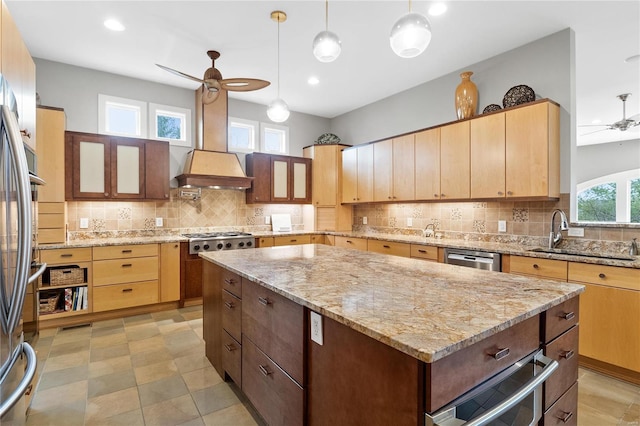 kitchen with ceiling fan, sink, a center island, and custom range hood