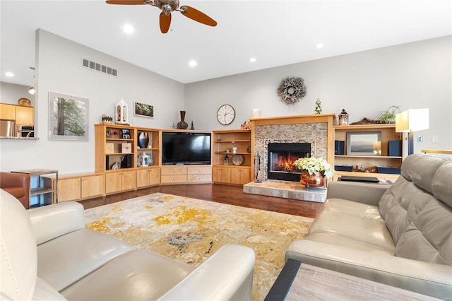 living room featuring hardwood / wood-style floors, ceiling fan, and a premium fireplace