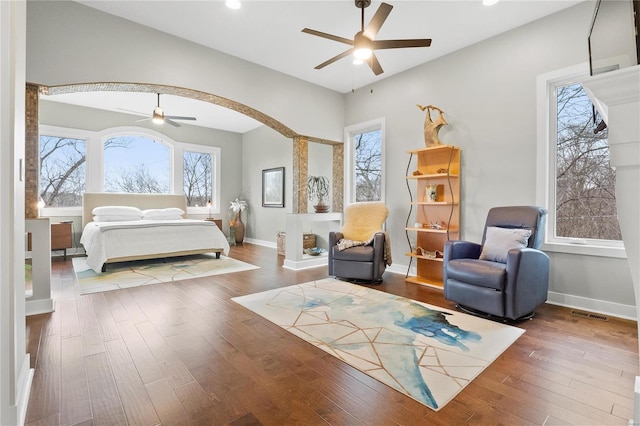 bedroom featuring hardwood / wood-style flooring, ceiling fan, and multiple windows