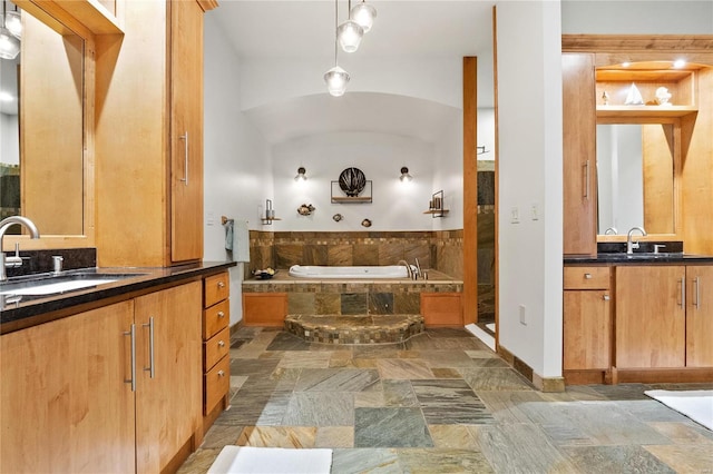 bathroom with tiled bath, vanity, and vaulted ceiling