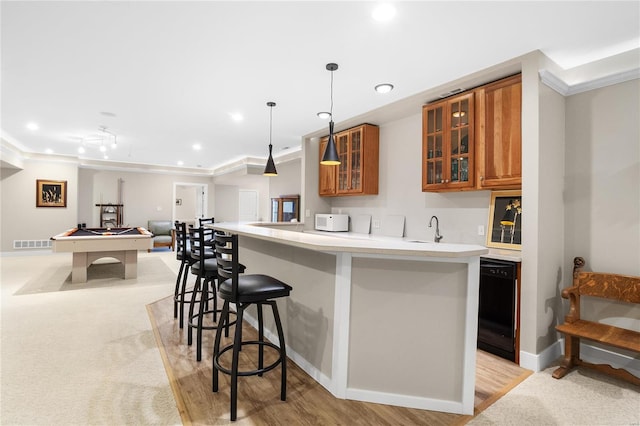 kitchen with pendant lighting, sink, billiards, ornamental molding, and black dishwasher