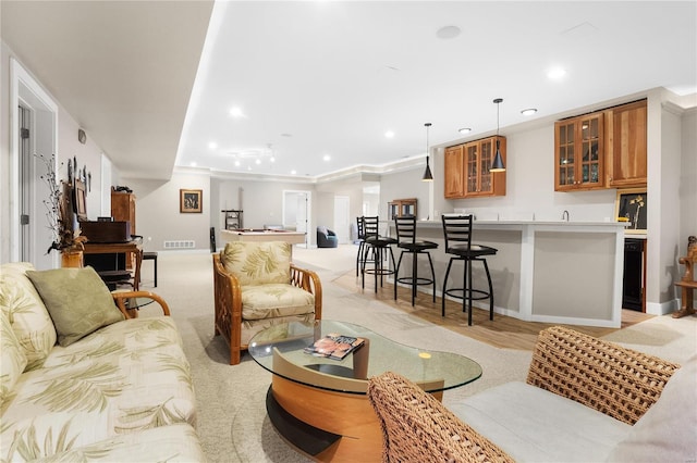 living room featuring bar area and crown molding