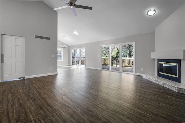 unfurnished living room featuring hardwood / wood-style flooring, ceiling fan with notable chandelier, and high vaulted ceiling