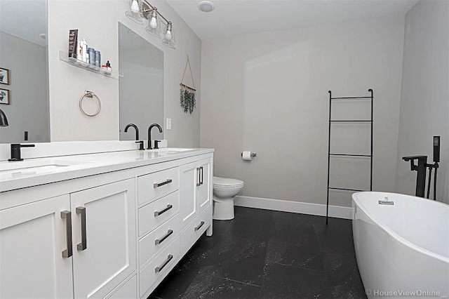 bathroom with a washtub, vanity, and toilet