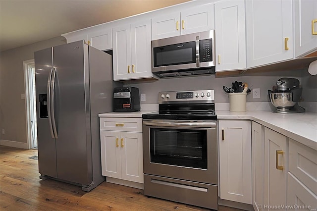 kitchen featuring white cabinets, stainless steel appliances, and hardwood / wood-style flooring