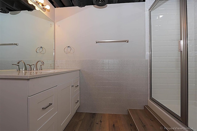 bathroom featuring walk in shower, vanity, tile walls, and hardwood / wood-style flooring