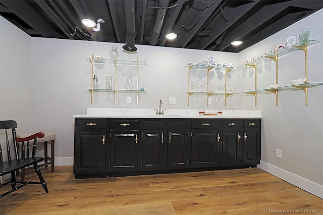 bar with sink and light hardwood / wood-style flooring