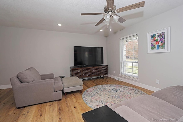 living room with ceiling fan and hardwood / wood-style floors