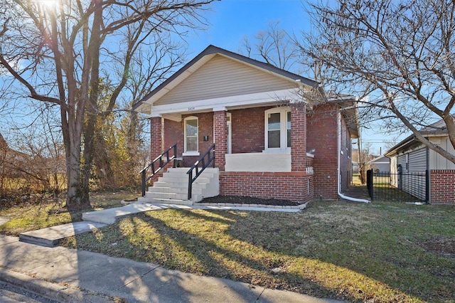 bungalow-style home with covered porch and a front yard