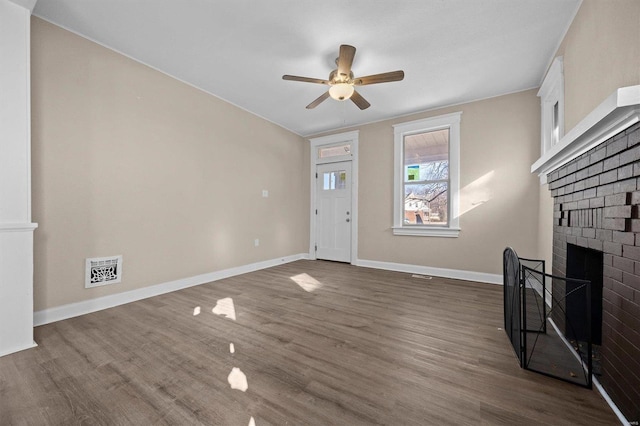 unfurnished living room with ceiling fan, dark hardwood / wood-style flooring, and a fireplace