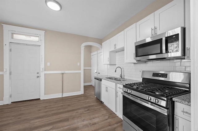 kitchen with light stone counters, sink, white cabinetry, and stainless steel appliances