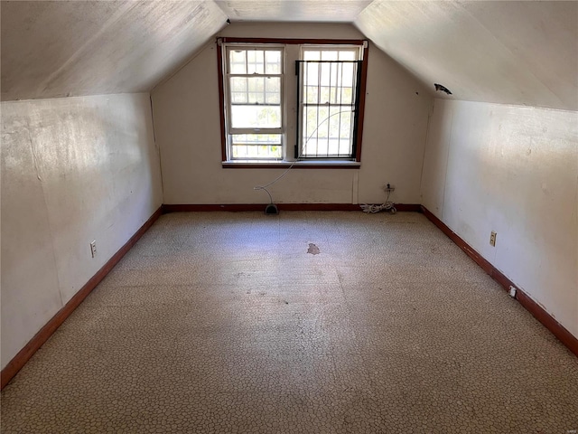 additional living space featuring carpet floors and lofted ceiling