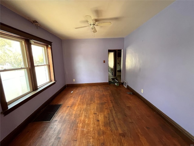 empty room with ceiling fan and dark hardwood / wood-style floors