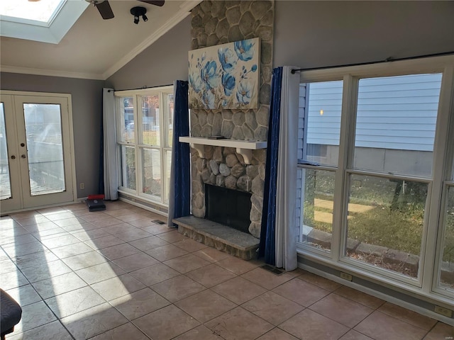 unfurnished living room with light tile patterned floors, lofted ceiling with skylight, and plenty of natural light