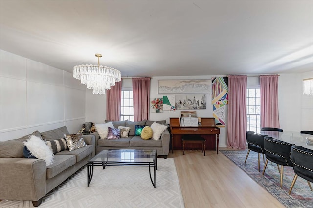 living room featuring light wood-type flooring and an inviting chandelier