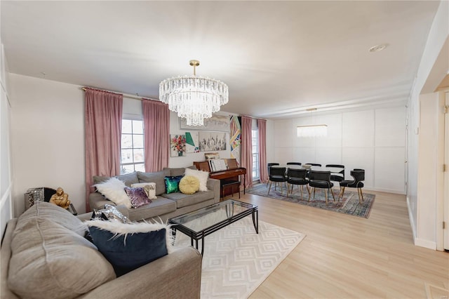 living room with light wood-type flooring and an inviting chandelier