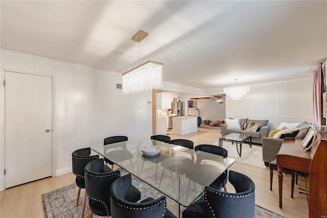 dining area with light hardwood / wood-style flooring and a chandelier