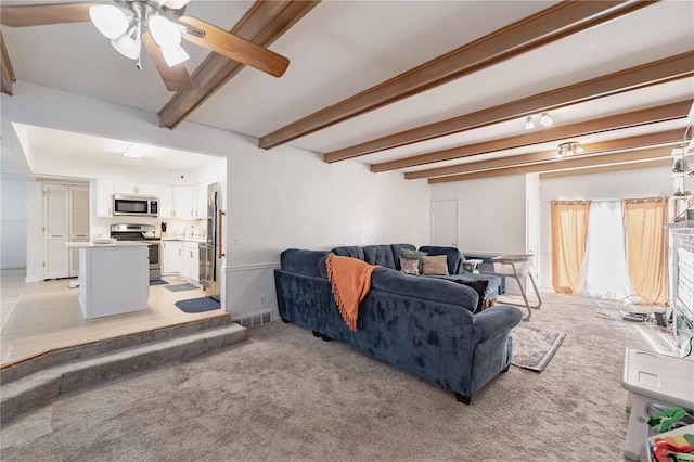 carpeted living room featuring beamed ceiling and ceiling fan