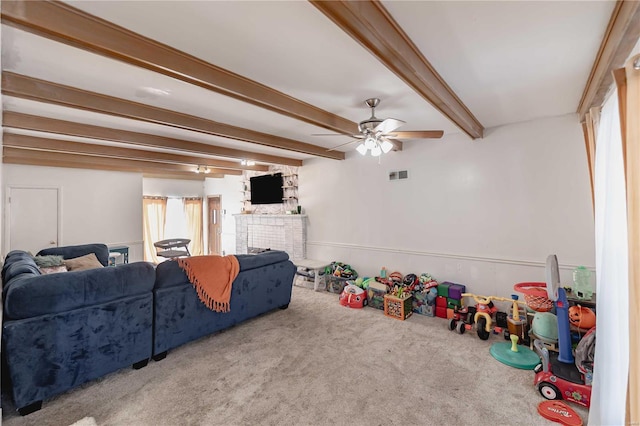 recreation room with carpet flooring, beam ceiling, and ceiling fan