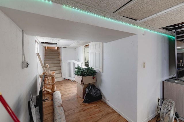 hallway featuring hardwood / wood-style flooring and a drop ceiling