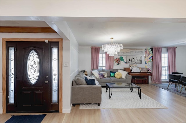 foyer with an inviting chandelier and hardwood / wood-style flooring