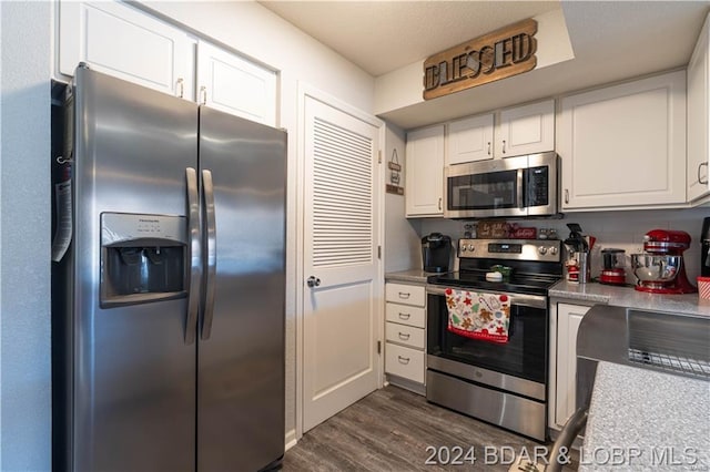 kitchen featuring backsplash, white cabinets, stainless steel appliances, and dark hardwood / wood-style floors